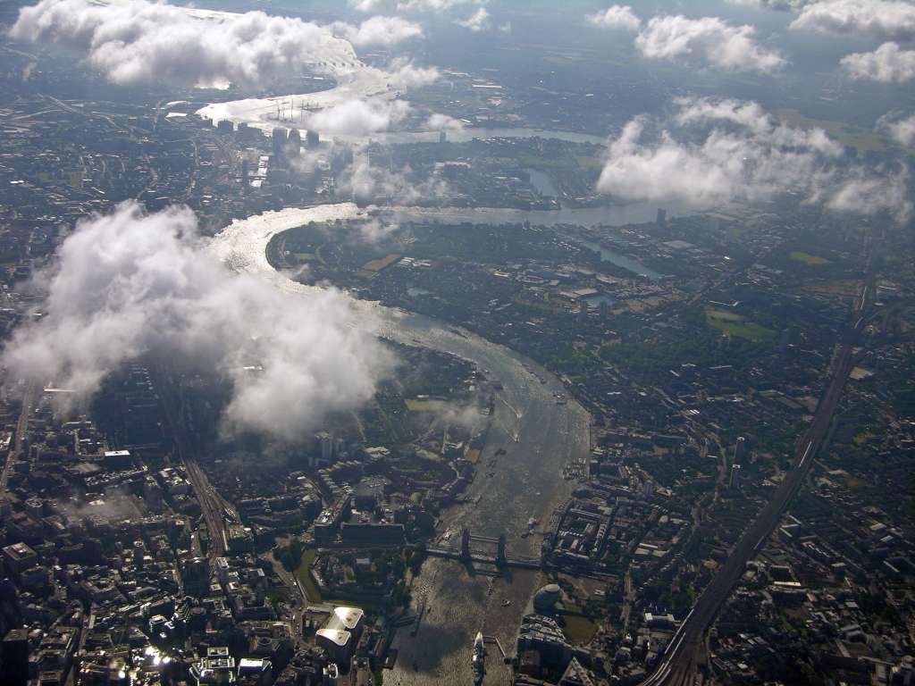 London 01 02 From Air As we flew into London, we had a great view of the Thames and the Tower Bridge. To the lower left of the bridge is the Tower of London. Canary Wharf is above to the left of the big curve in the Thames. The Royal Observatory at Greenwich is the green field to the right of the big curve in the Thames. The Thames Barrier is the pylons in the Thames are just left of centre near the top of the photo.